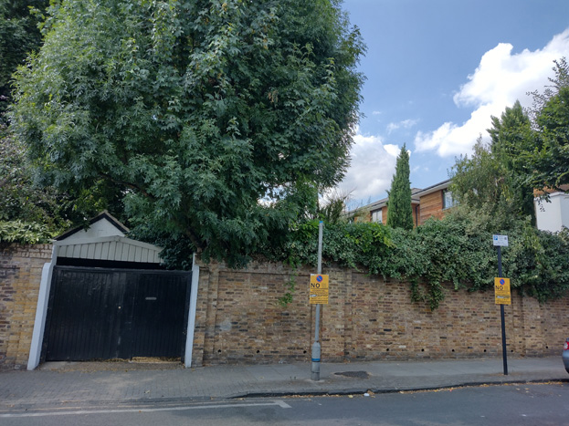 Fig. 10: The robust boundary wall of the former college dominates the west side of Sutherland Grove for much of it's length
