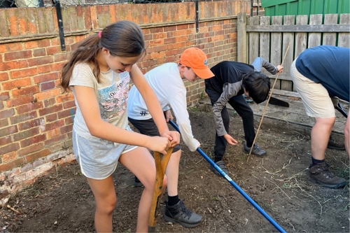 A group of young people dig a garden